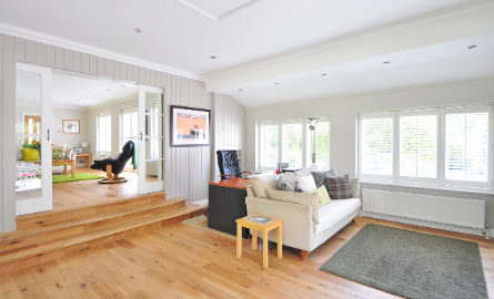 interior of apartment, couch and table, wood floor, windows 